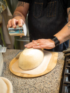 George Relyea sprinkles flour onto his sourdough before it goes in the oven