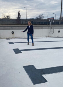 Danielle Crooke, executive director of the City of Evansville Department of Parks and Recreation, demonstrating damage in cracks inside Hartke Pool.