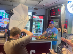 Photo of Brodie Curtsinger photographing Casey’s Dugout owner Casey Keown provided by Casey’s Dugout. Keown paused for a photo during the dinner rush May 29. See more of Curtsinger’s images from this photo shoot at the East Side pizzeria in an upcoming issue of Evansville Living.