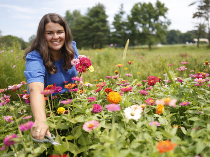 Photo of Ellie Ziliak among The Zinnia Meadow flowers by Brodie Curtsinger