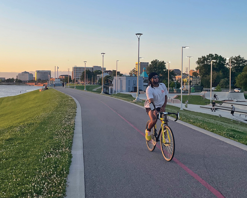 A cyclist on the Pigeon Creek Greenway Passage on the riverfront. Photo by Laura Mathis