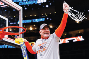 Bruce Pearl cuts a piece of the net after he coached the Auburn University men's basketball team to victory.