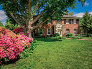 Patrick and Susan Lattner's is home surrounded by azalea bushes, trees, and blooming flowers.