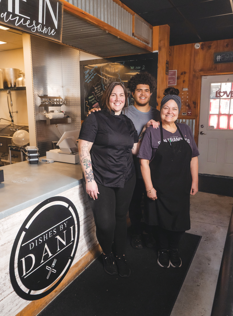 Dani Schiffer, Cris Carter, and Shannon Orr stand at the counter of Dishes By Dani, Schiffer's meals-to-go business.