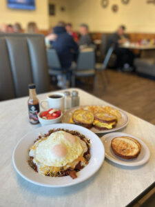 Diamonds Diner breakfast featuring hashstack with hash browns, sausage, egg, and cheese and the homestyle cinnamon slammer, a sausage, egg, and cheese breakfast sandwich on cinnamon swirl bread. Photo by Chanda Ramsey