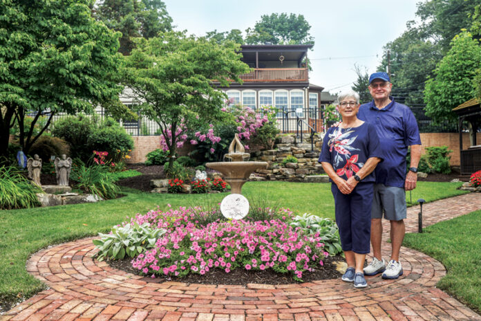 Jim and Mary Ann Wilsbacher stand in God's Garden, their publicly accessible garden just off the Rivertown Trail in Newburgh, Indiana.