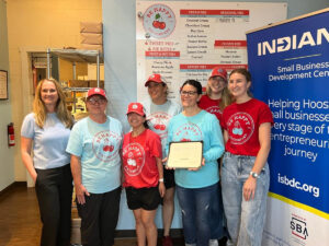 Women stand with an award plaque