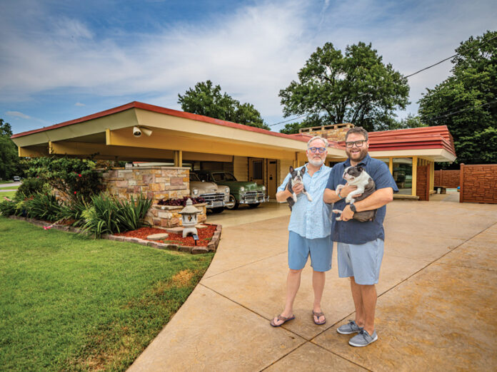 Photo by Zach Straw. Guy Crouch and Justin Tommeraus pose with their Boston Terriers, Percy and Simon, in front of the mid-century modern home in the historic Hebron Meadows neighborhood.